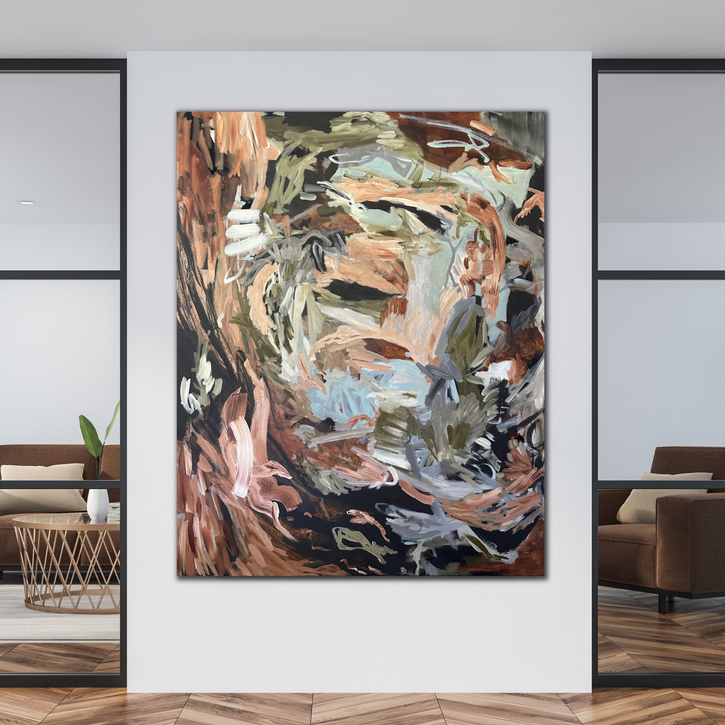 A lively abstract artwork featuring earthy colour tones displayed on a white wall in a contemporary living room setting.