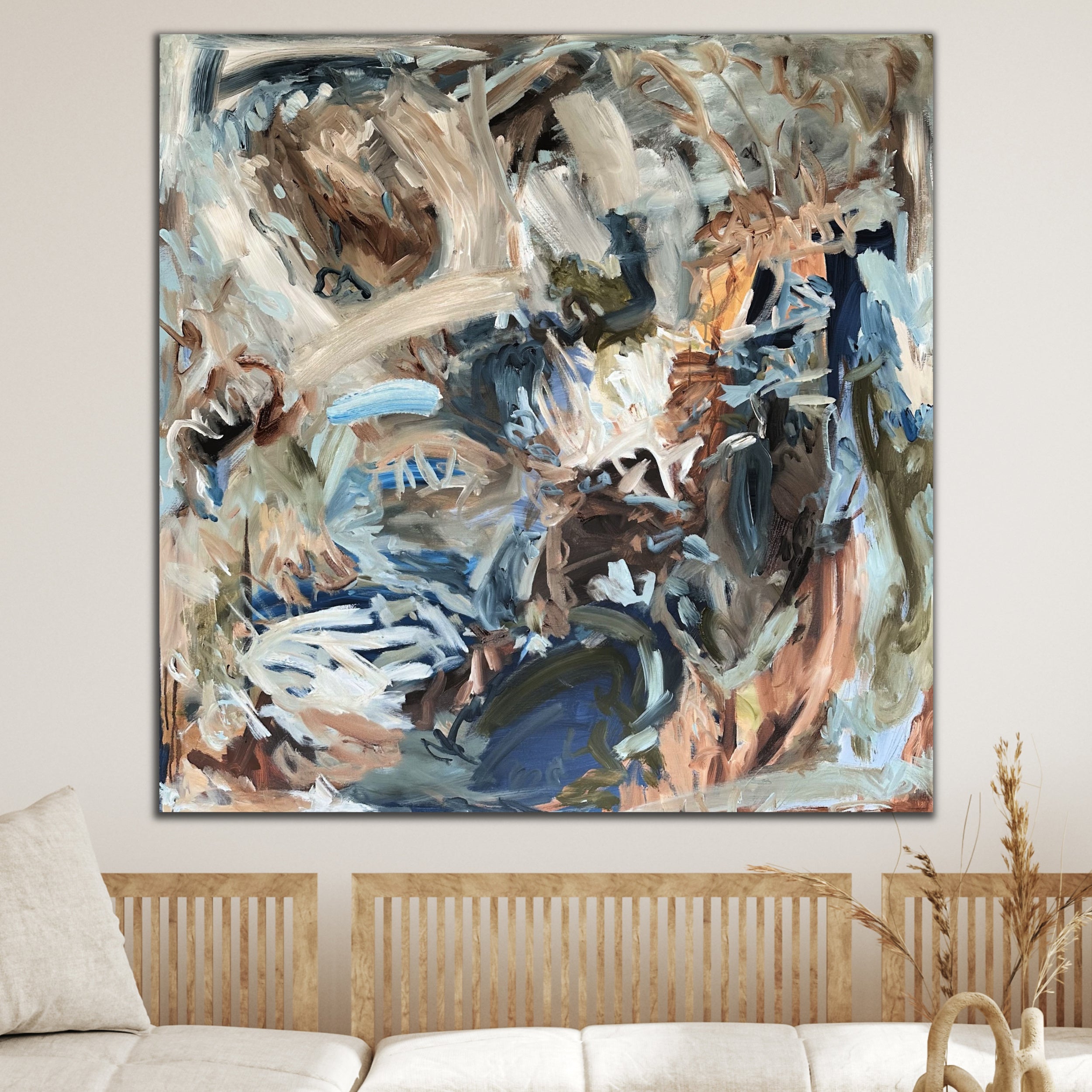 Square abstract painting inspired by nature in blue, brown, beige, white and olive green in neutral interior with natural furnishings