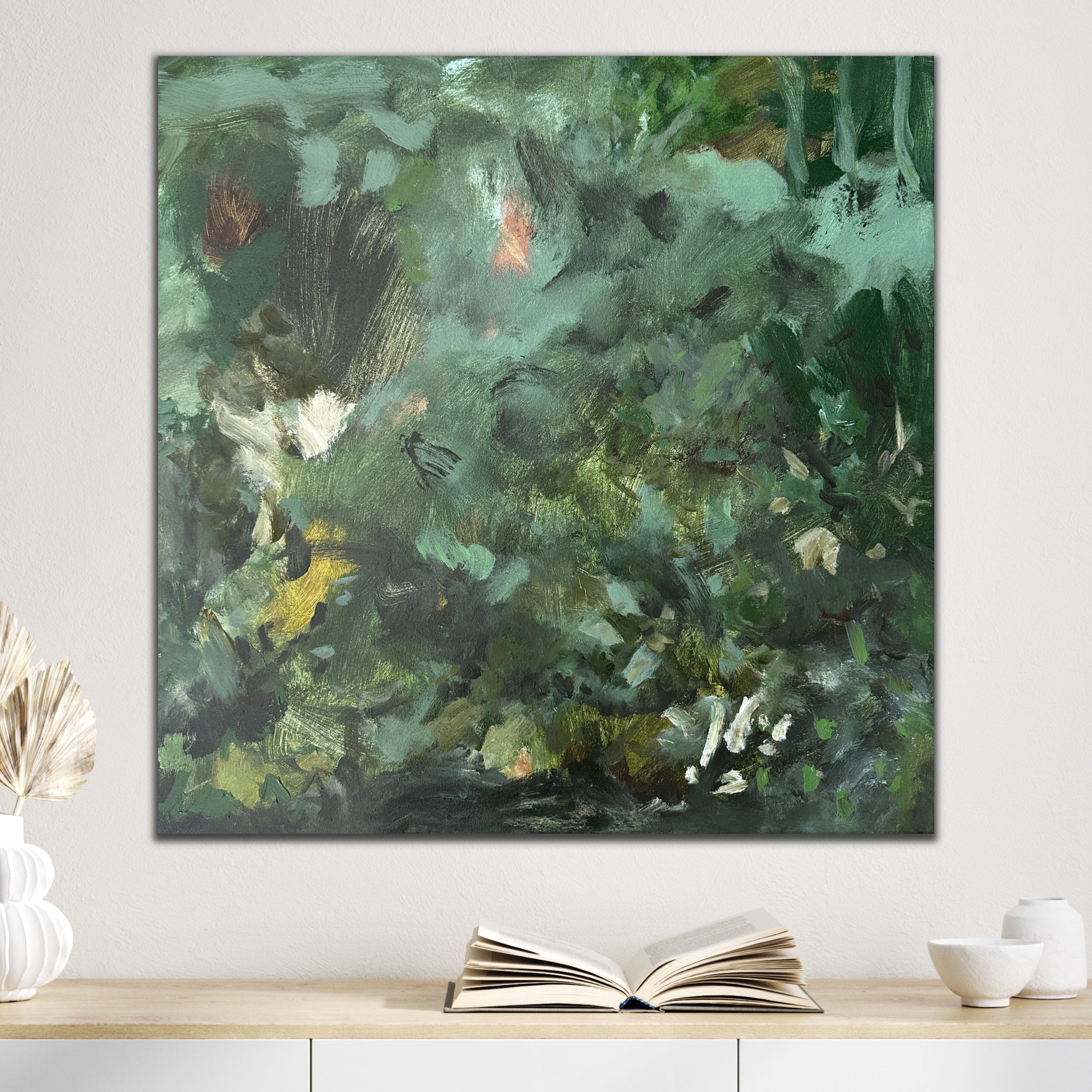 Abstract expressionist painting in green and brown tones hanging on wall in neutral interior