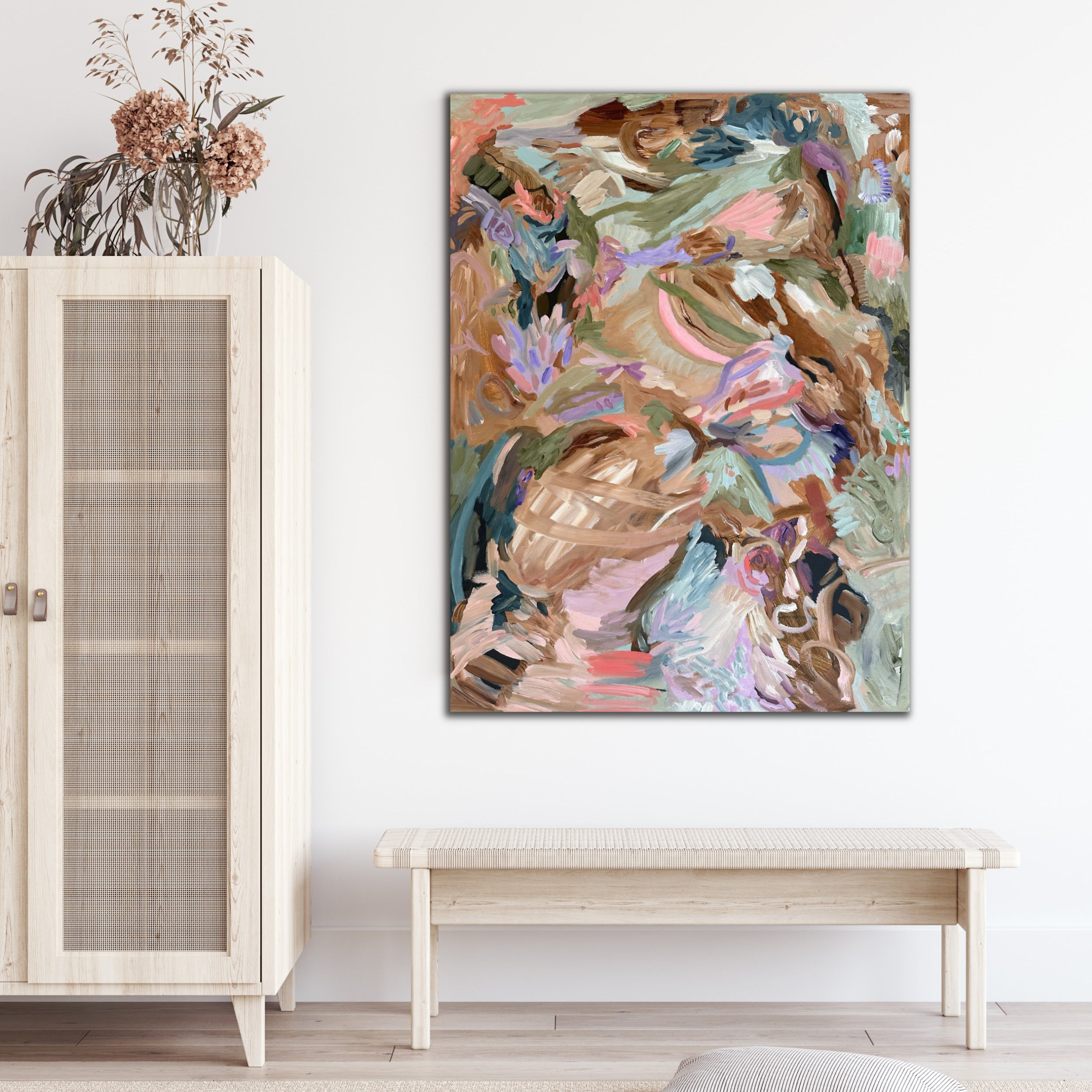 Expressive abstract landscape painting of nature and plants hanging on wall in entry way of home with natural furniture and fittings