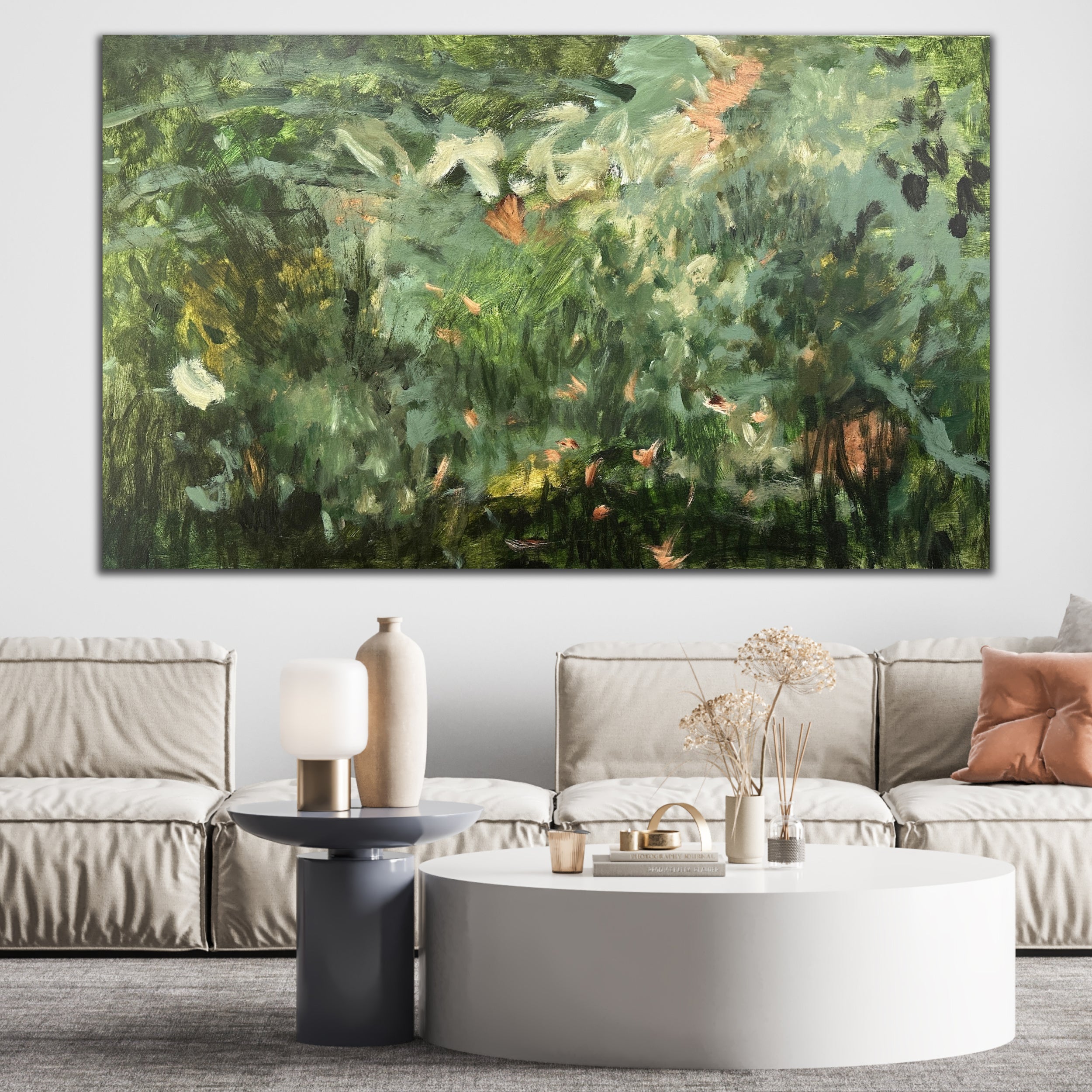 Large painting with green and natural tones hanging on wall in modern neutral living room