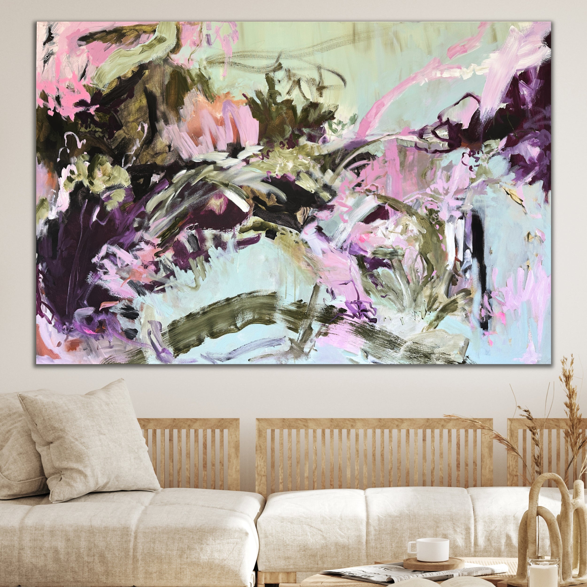 Bold, playful abstract artwork inspired by love and freedome with sweeping gestures hanging on wall in modern living room with natural furnishings