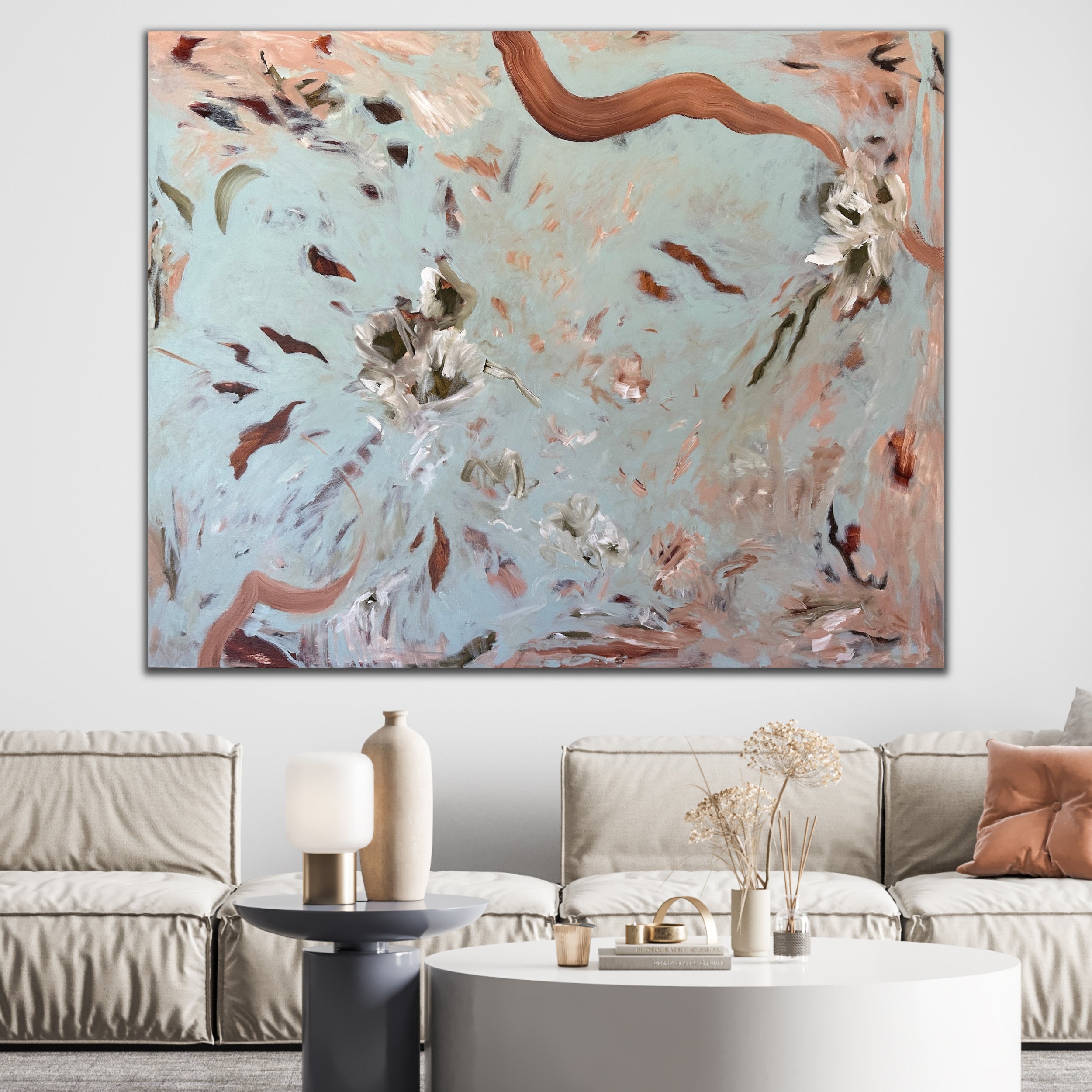 Large painting in abstract floral style in soft blue, beige and brown hanging above sofa in luxury, designer living room