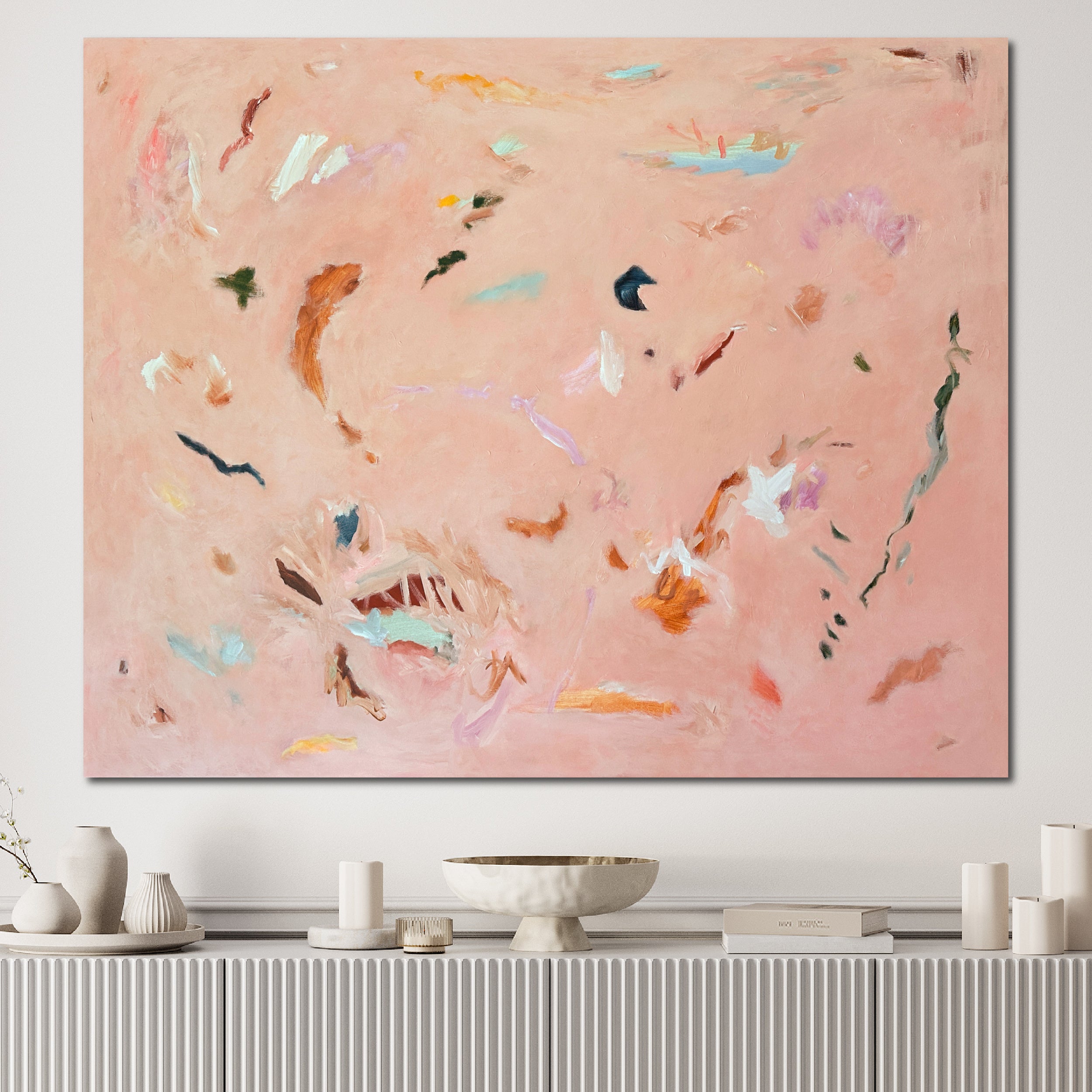 Large contemporary abstract painting "Whispered Words" in peachy pink hanging on wall in contemporary interior with white furnishings