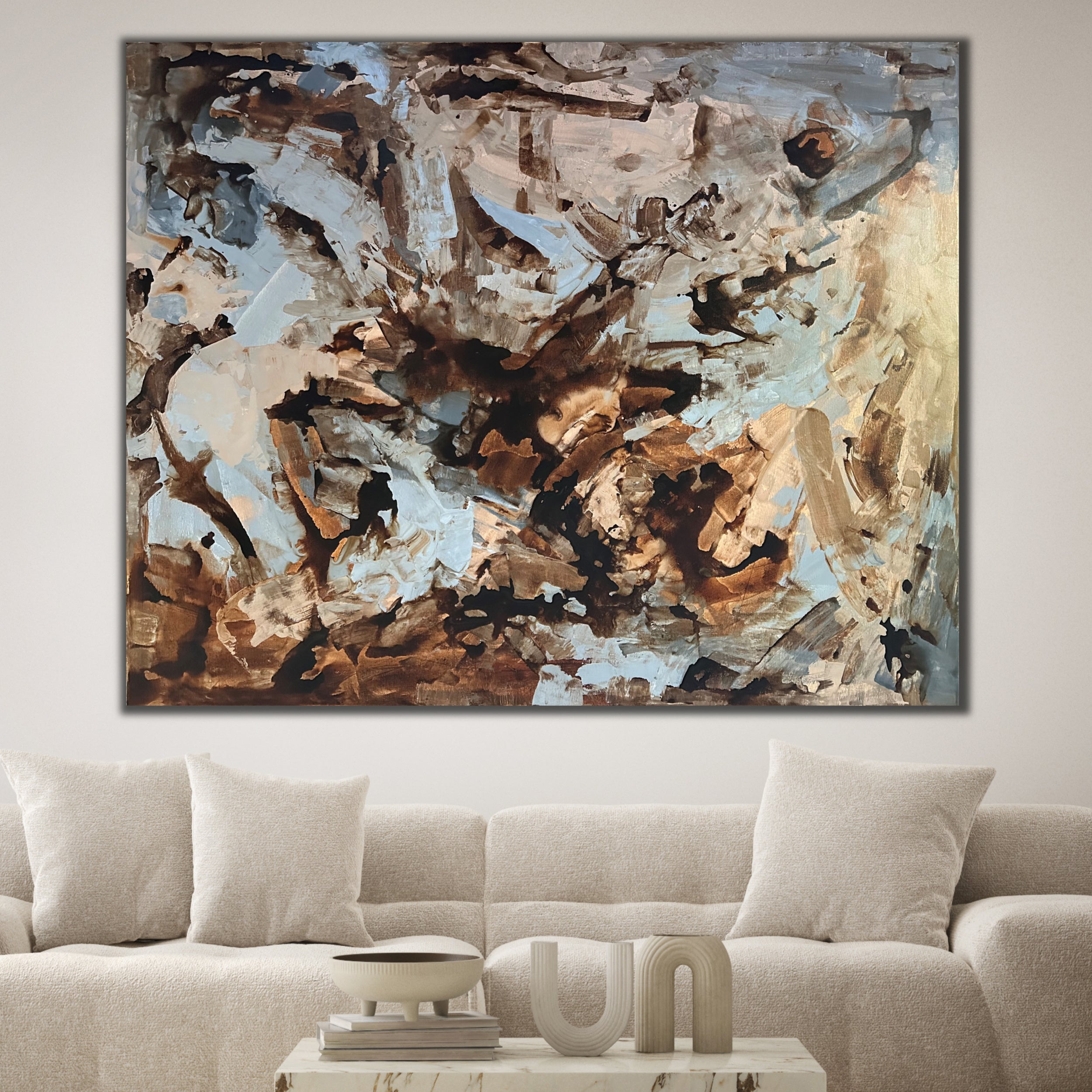 Big brown abstract painting hanging over lounge in minimalist modern living room