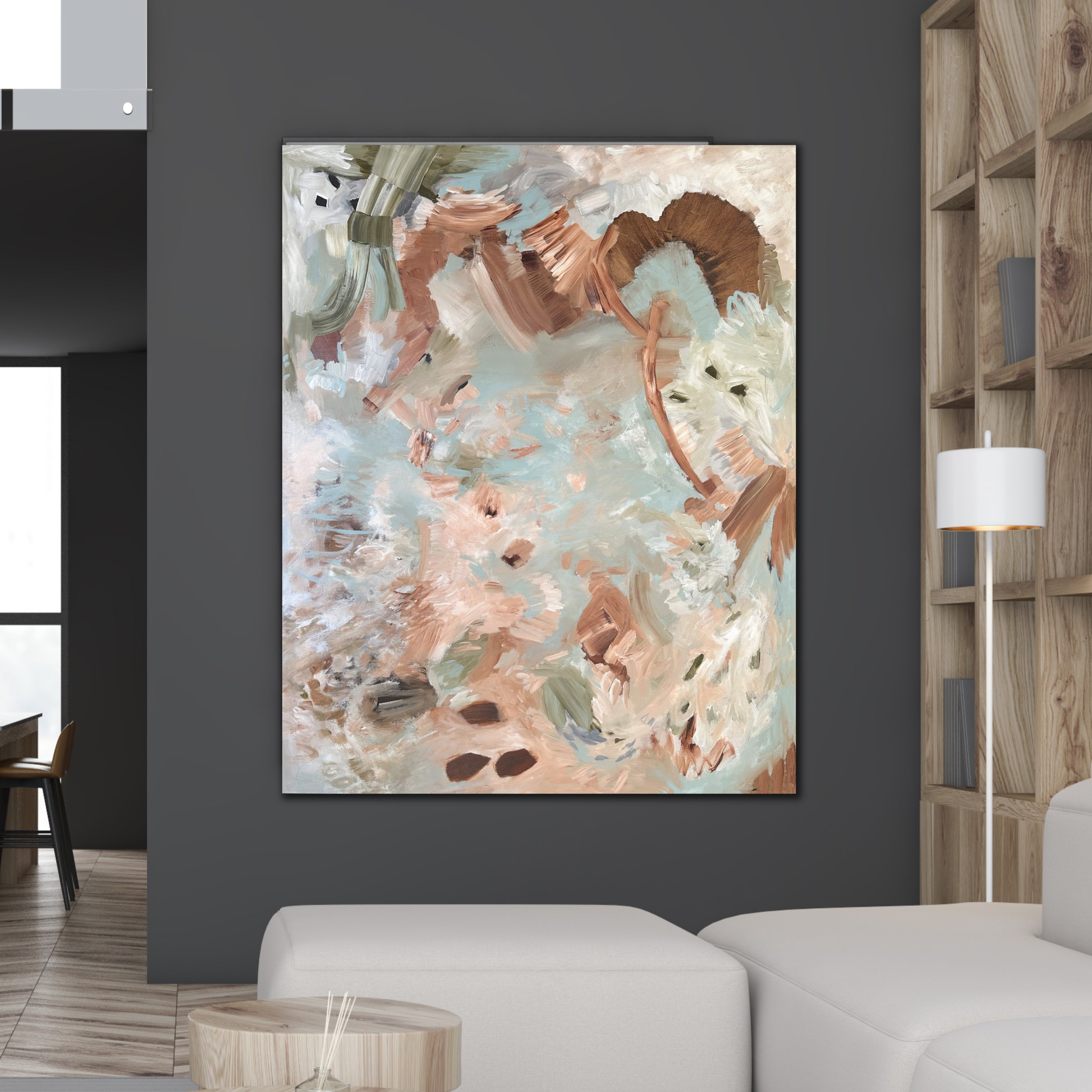 A large abstract painting on canvas with textured brushstrokes in beige, brown, white, olive green and light blue, displayed on a dark gray wall in a modern living room setting.