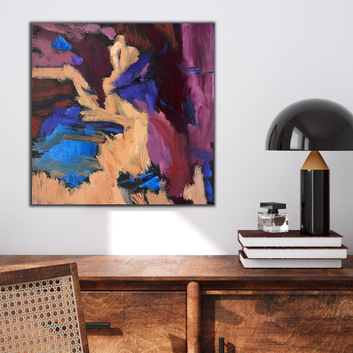 Contemporary abstract painting in blue, maroon, red, apricot and purple hanging above wooden sideboard.