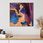 Small abstract painting in pink, burgundy, purple, blue, black and beige, hanging on wall in modern interior. 