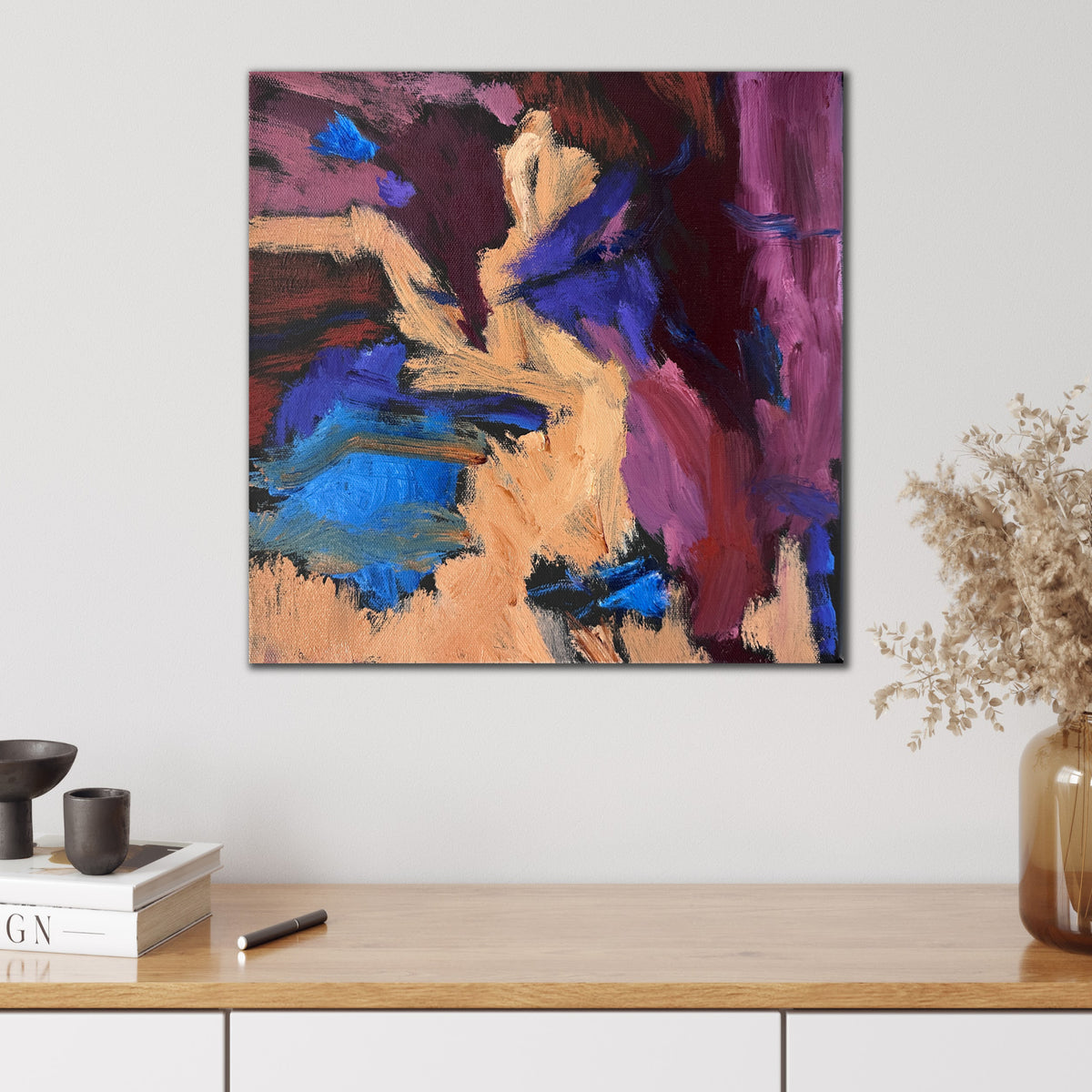 Small abstract painting in pink, burgundy, purple, blue, black and beige, hanging on wall in modern interior. 