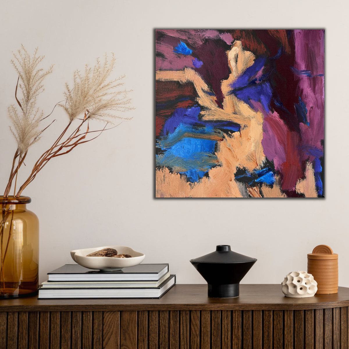 Small abstract painting hanging in contemporary home with neutral furnishings. 