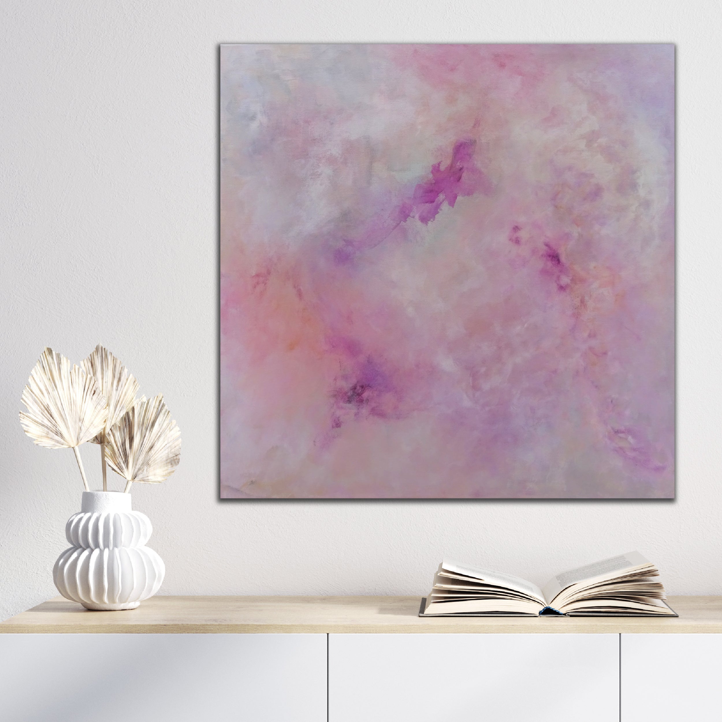 Pretty, modern abstract painting in shades of pink that feels mystical and magical hanging above cupboard in modern neutral interior space - in situ