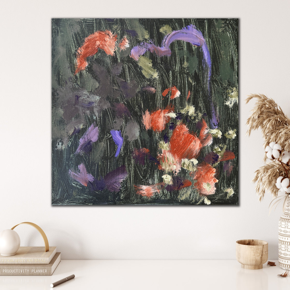 Abstract artwork in gestural, expressive painting style hanging on wall in home with decorative accessories in natural finishes. 