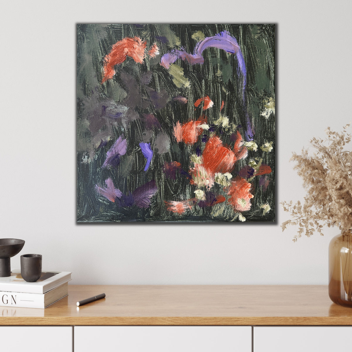 Expressive abstract painting in shades of green, burnt orange, purple and black hanging on wall in modern interior with natural, neutral furnishings and decorative accessories. 