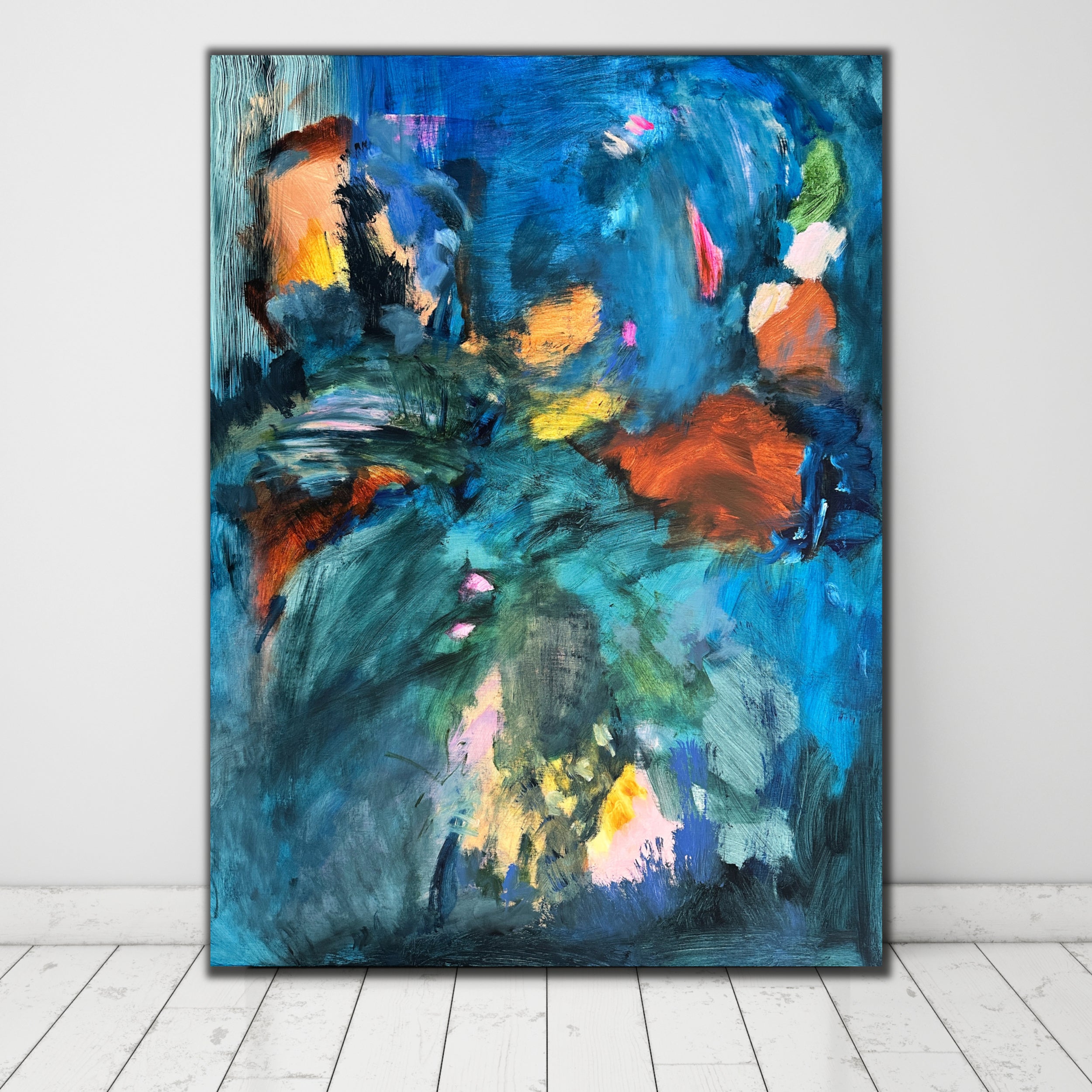 Vibrant blue abstract painting leaning on wall in white room