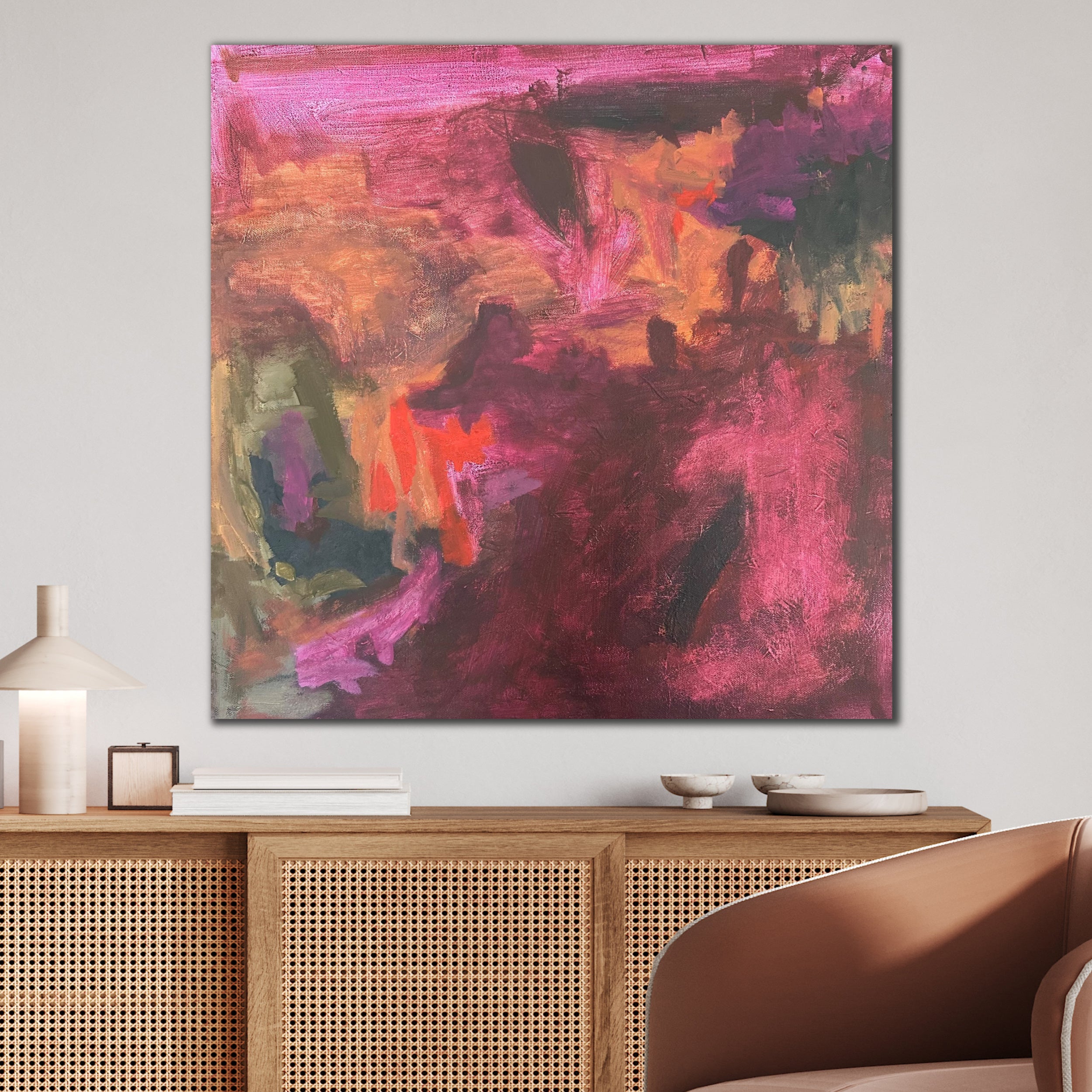 Gestural abstract landscape painting in warm colours hanging in contemporary living room interior with neutral furnishings