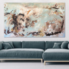 Large abstract artwork in shades of blue, brown and white hanging above lounge in modern living room