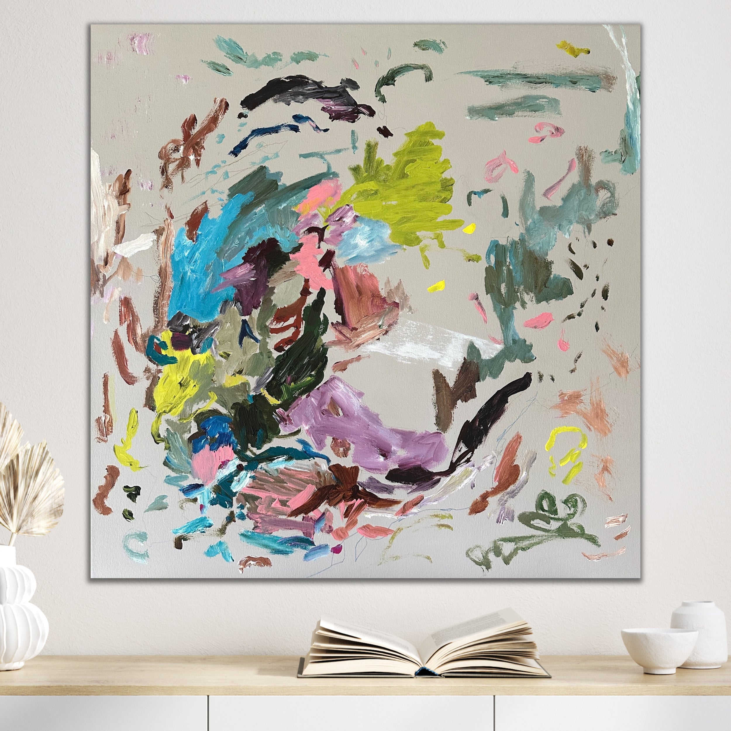 Fun abstract painting in bright colours on square canvas hanging on wall in neutral modern room
