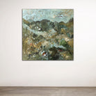 Abstract painting of nature scene hanging on a white wall