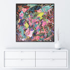 Square abstract painting with botanical influence in bright colours of pink, , green, blue and yellow hanging on wall in minimalist white interior