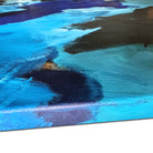 Close-up detail of edge of blue abstract painting on canvas showing gestural brushstrokes in shades of blue and brown
