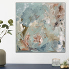 Small, square blue abstract painting inspired by nature and flowers on canvas hanging in modern home